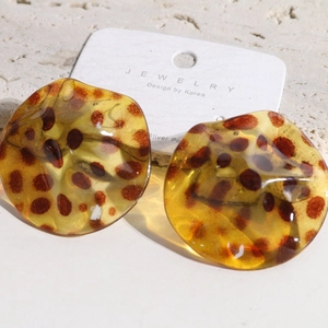 Macro view of leopard print resin earrings with wavy texture and 925 silver posts