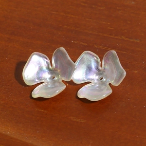 Macro shot of iridescent acrylic clover beads with aurora finish for DIY jewelry crafts