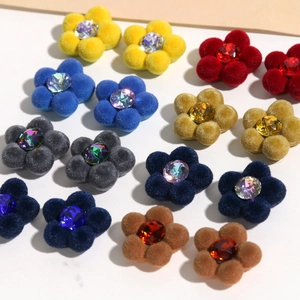 Nahaufnahme bunter beflockter Blumenanhänger mit Kristallzentren für DIY-Schmuckherstellung