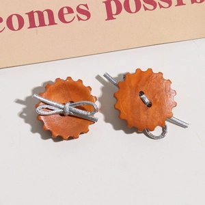 Detalle de engranajes de madera naranja vintage con lazo plateado y acentos metálicos