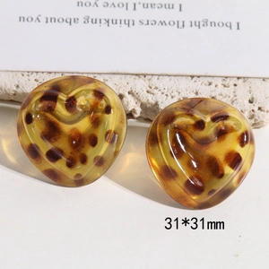 Detail of 31x31mm heart-shaped leopard print resin earrings on a stone textured background