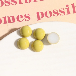 Makroaufnahme limettengrüner Acryl-Halbperlen mit glänzender Oberfläche und flacher Basis