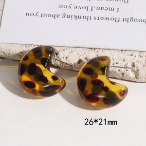 Detail view of 26x21mm leopard print C-shape resin earrings with warm amber tones