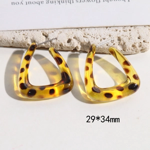 Detail view of large C-shaped leopard print acrylic earrings measuring 29mm by 34mm