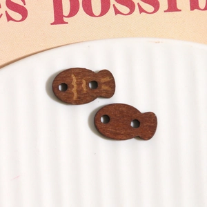 Detailed macro view of small fish-shaped wooden buttons for DIY jewelry and crafts