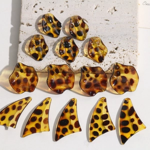 Macro detail of leopard print resin leaf charms for DIY earrings and jewelry making