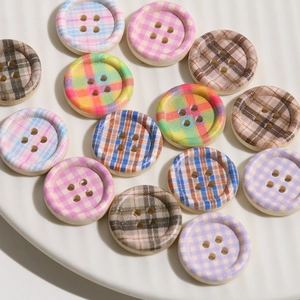 Detail of wooden checkerboard buttons in pink and blue on a ceramic tray for DIY sewing