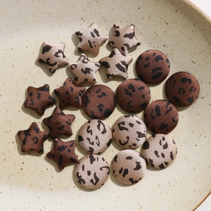 Macro detail of leopard print star and round buttons in a ceramic dish accessory