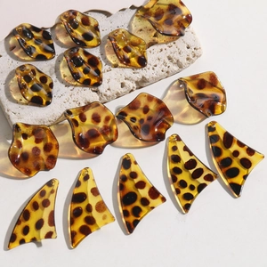 Macro detail of leopard print resin leaf charms for DIY earrings and jewelry making