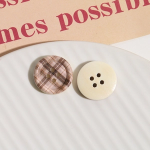 Macro shot of 4-hole round wooden buttons with checkerboard print and cream white finish