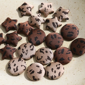 Macro shot of leopard print star and round fabric buttons for sewing and crafts