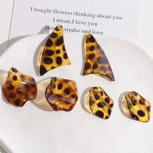 Detailed view of leopard print resin leaf charms and petals on a white decorative plate