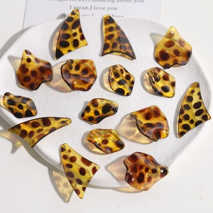 Detailed view of amber leopard print resin charms in various irregular shapes for DIY jewelry