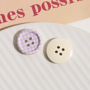 Detail of round wooden buttons with purple checkered pattern and off-white glossy finish
