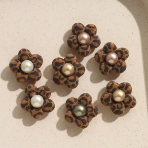 Macro detail of seven flocking leopard print flower charms with colorful pearl centers