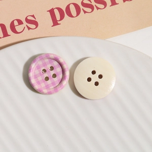 Close-up of checkerboard and plain wood buttons on a white ceramic plate for DIY sewing