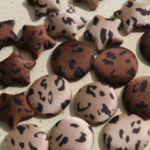 Macro detail of star and round leopard print fabric buttons for DIY fashion accessories