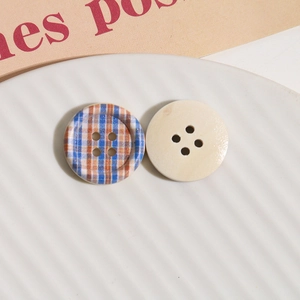 Macro detail of checkered wooden buttons for DIY sewing on a textured ceramic plate