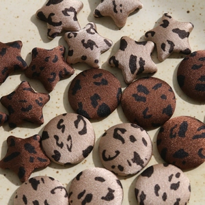 Detailed view of leopard print star and round fabric buttons for DIY accessories