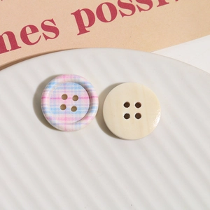Macro detail of round four-hole wooden buttons with pink checkered print and cream texture