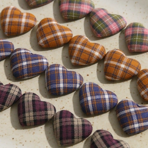 Close-up of heart-shaped plaid fabric buttons and DIY handmade craft accessories