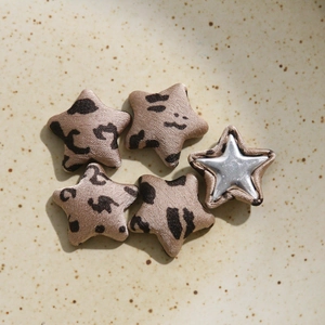 Close-up of leopard print star-shaped buttons and satin fabric fashion accessories