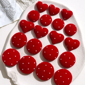 Macro view of red velvet polka dot heart and round buttons for DIY jewelry crafting