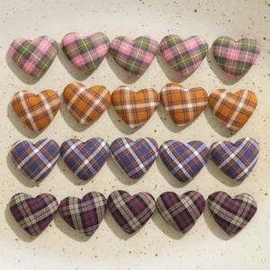 Macro view of assorted plaid fabric heart patches for DIY accessories and sewing