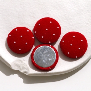 Close-up of red velvet polka dot round buttons for DIY jewelry with silver metal backing