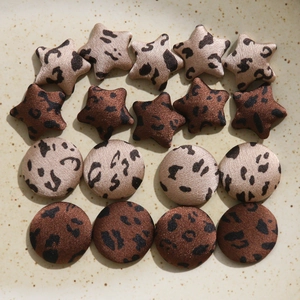 Macro view of leopard print star and round fabric buttons for DIY accessories