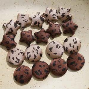 Detailed view of leopard print star and round fabric buttons for DIY crafts and sewing