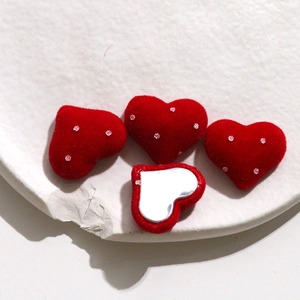 Detailed view of red velvet heart buttons with glitter accents for DIY jewelry crafts