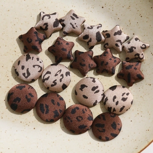 Detail of leopard print fabric covered star and round buttons in vintage brown tones