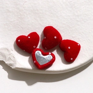 Macro shot of red velvet heart-shaped DIY accessories with white dots and silver inlay