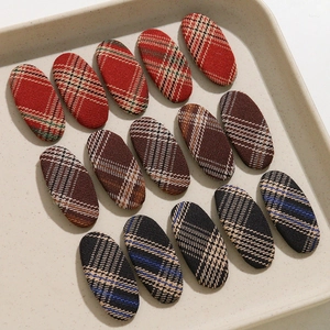 Détail macro de barrettes à cheveux ovales en tissu à carreaux sur un plateau