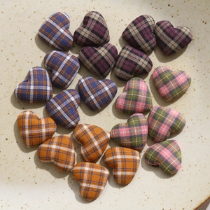Macro shot of assorted heart-shaped plaid fabric buttons on a decorative ceramic plate