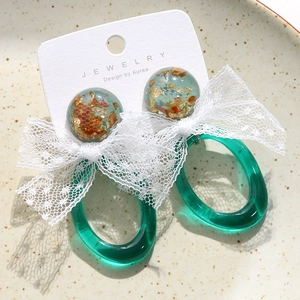 Boucles d'oreilles vintage en résine avec feuille d'or et nœud en dentelle sur céramique