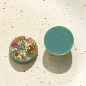 Vue détaillée de cabochons en résine faits main avec feuilles d'or et maille alvéolée
