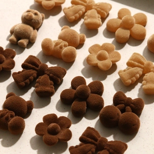 Macro view of flocked DIY accessories featuring brown plush bears, flowers, and bows