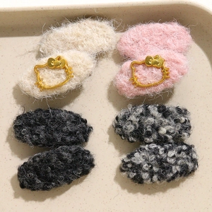 Set of four plush faux wool hair clips in cream, pink, black, and grey with kitty charm