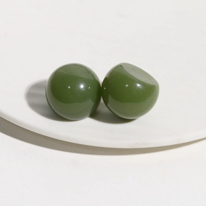 Detail of dark green resin dome studs with a glossy finish for DIY hair accessories