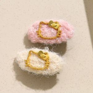 Detailed view of plush knitted hair clips featuring gold Hello Kitty character contours