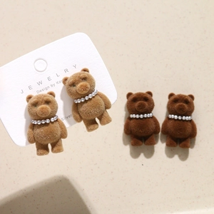 Close-up of flocking brown bear jewelry parts with white pearl necklace details