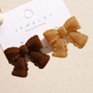 Macro shot of flocked velvet bow earrings in brown and khaki with S925 silver posts