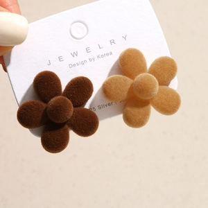 Detail of flower flocking earrings with 925 silver posts in brown and beige tones