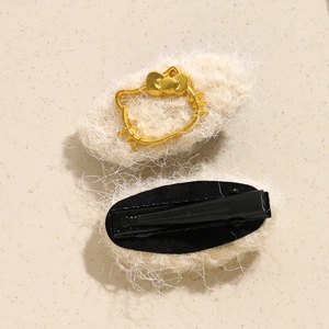 Front and back detail of plush cream hair clip with golden kitten silhouette and metal grip