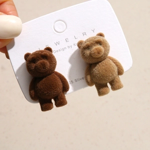 Close-up of cute flocked teddy bear earrings with 925 silver needles in coffee colors