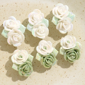 Vue macro de breloque rose 3D en céramique avec fini nacré et feuilles vertes pour bijoux