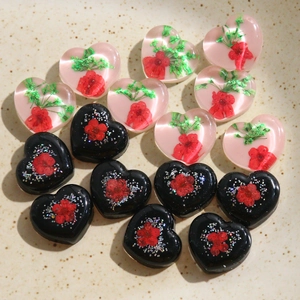Détail de breloques coeur en résine avec fleurs séchées et paillettes pour accessoires DIY