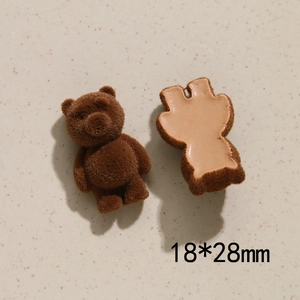 Macro shot of brown flocked bear DIY charm showing textured front and flat 28mm back side